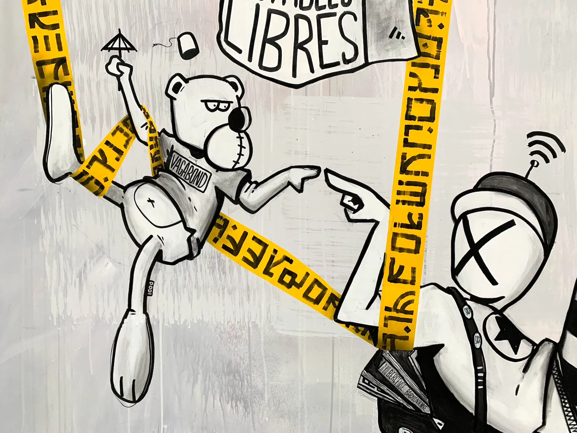 Détail d’une fresque en noir et blanc représentant des personnages dessinés avec des bulles de texte.