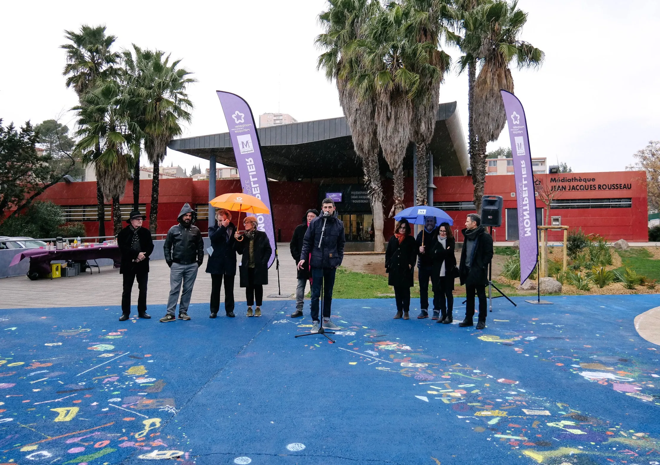 Photo d'une prise de parole à même la fresque réalisée au sol.