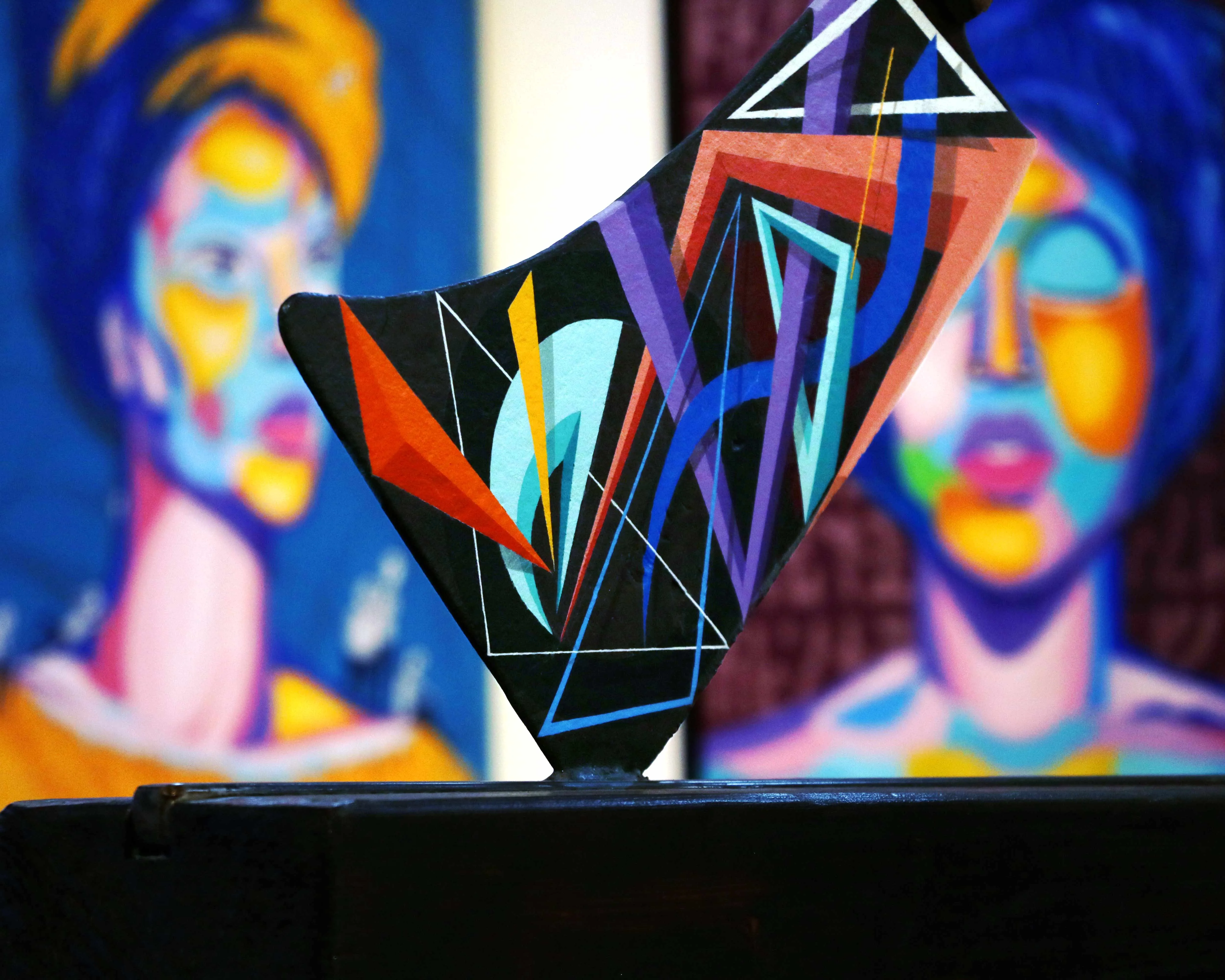 Détail de peinture figurative contemporaine aux formes graphiques et couleurs intenses sur une hache