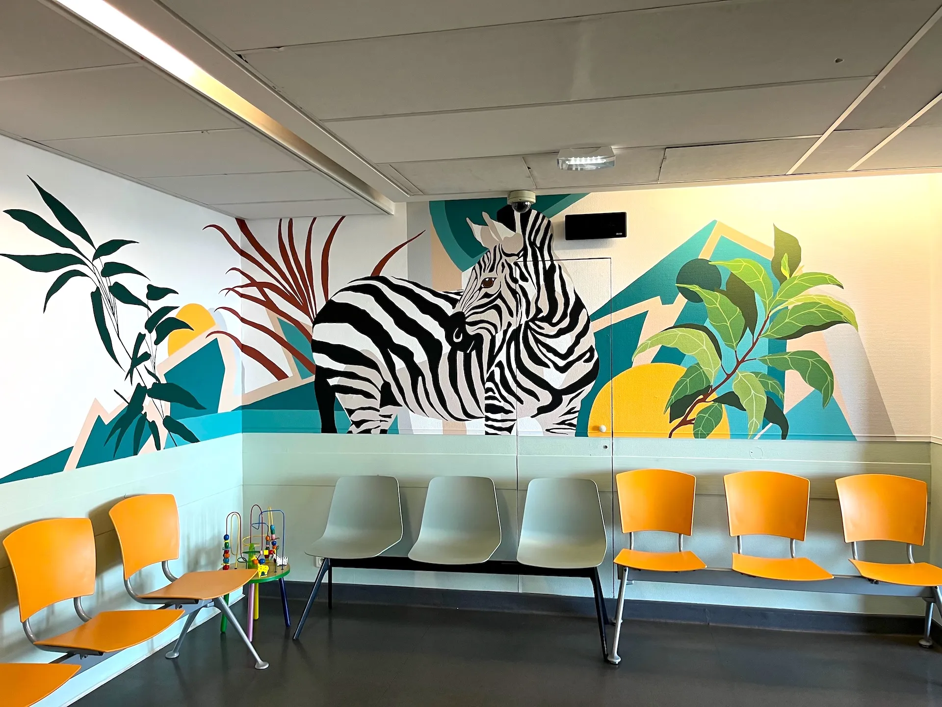 Oeuvre murale représentant un zèbre au milieu d'éléments végétaux.