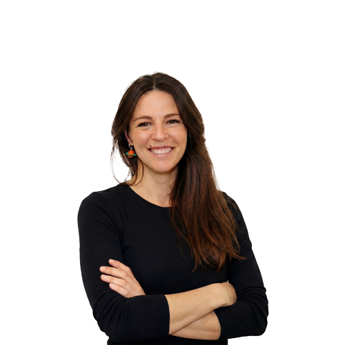 Dra Laia Sabiote de pie con brazos cruzados mirando a cámara con una camiseta negra y una sonrisa natural, cercana.