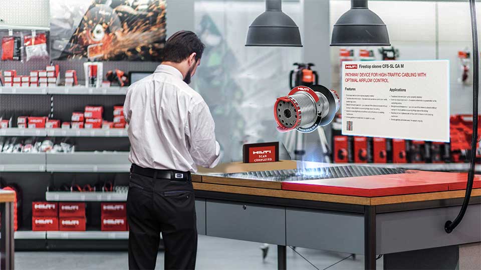 Man in a white shirt scanning a metal surface on a workbench with a Hilti device showing a holographic product image and information panel.