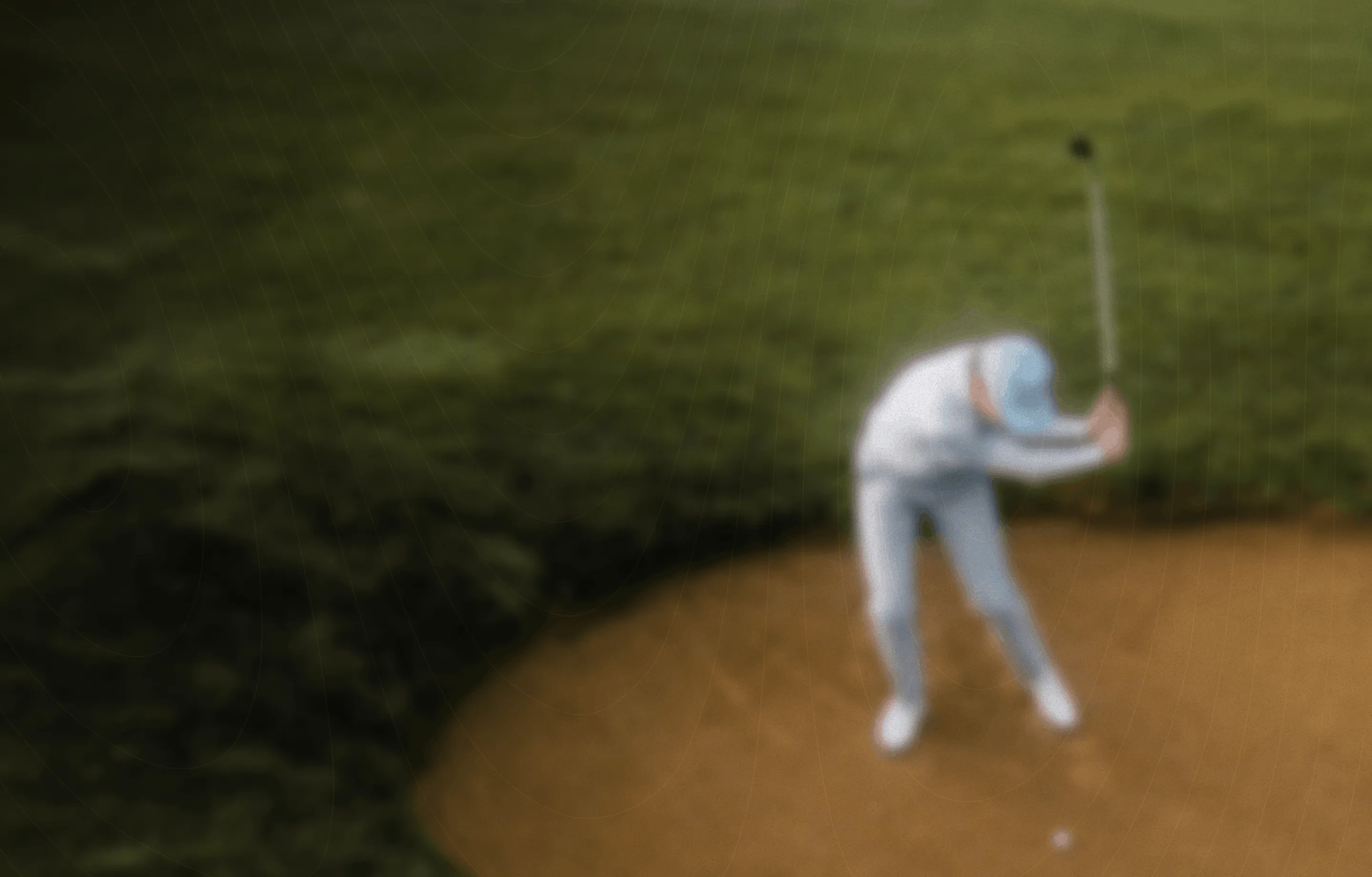 Blurred image of a golfer preparing to hit a ball from a sand bunker on a golf course.