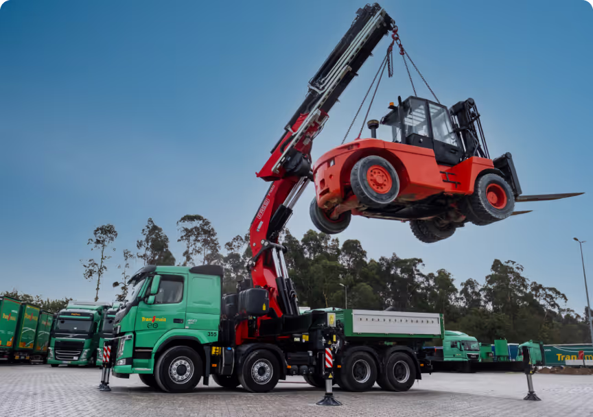 Camião grua da Transmaia a levantar empilhador industrial com grua extensível.