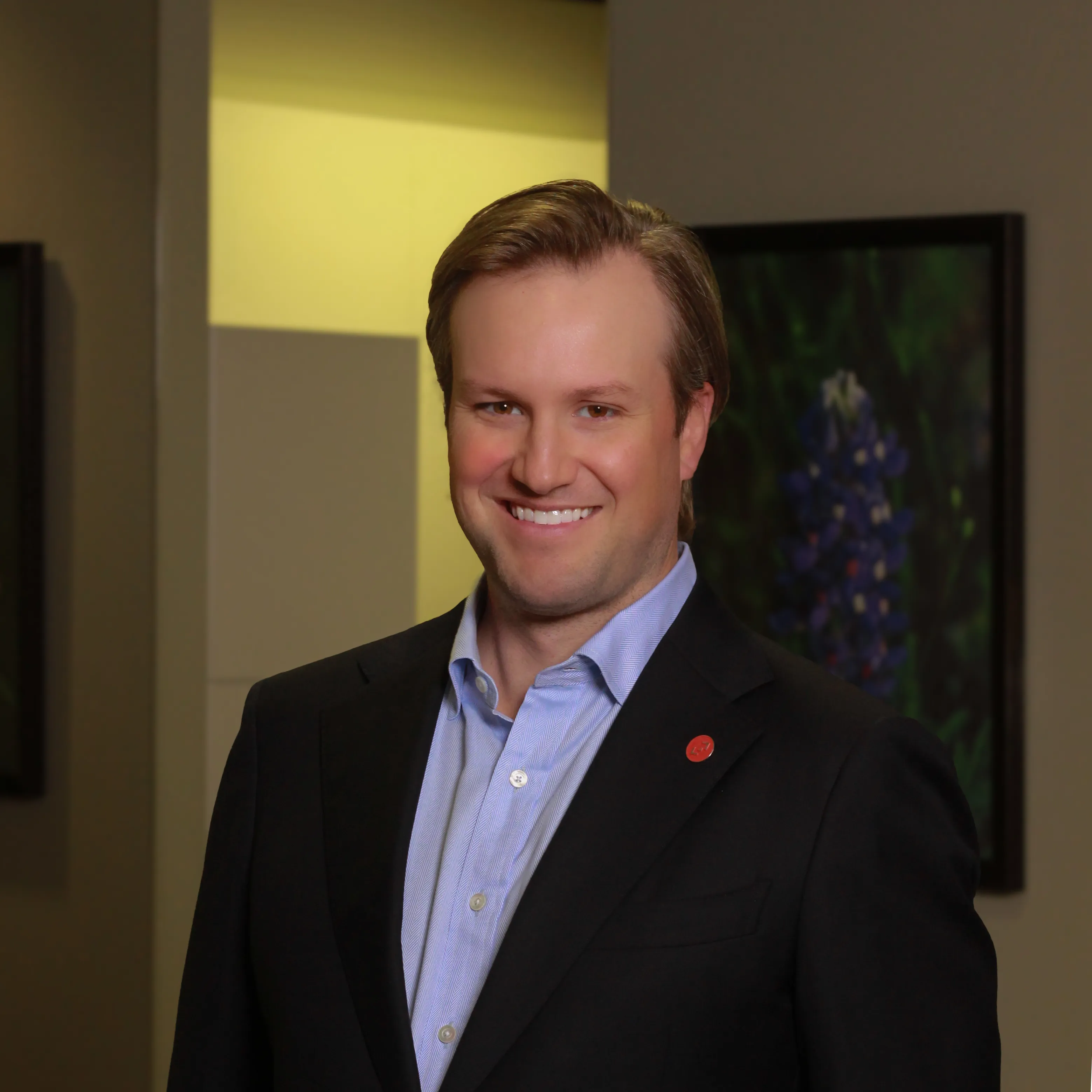 Dr. Reynolds Lawnin in a dark suit smiling in the office hallway