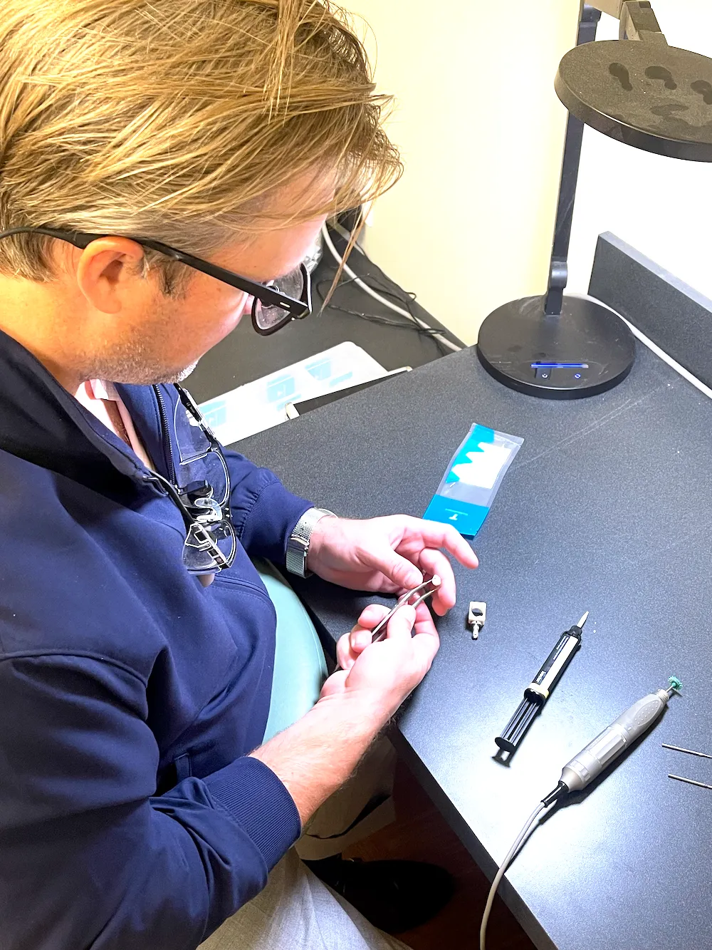 Dr. Reynolds Lawnin working on a dental restoration at a lab bench