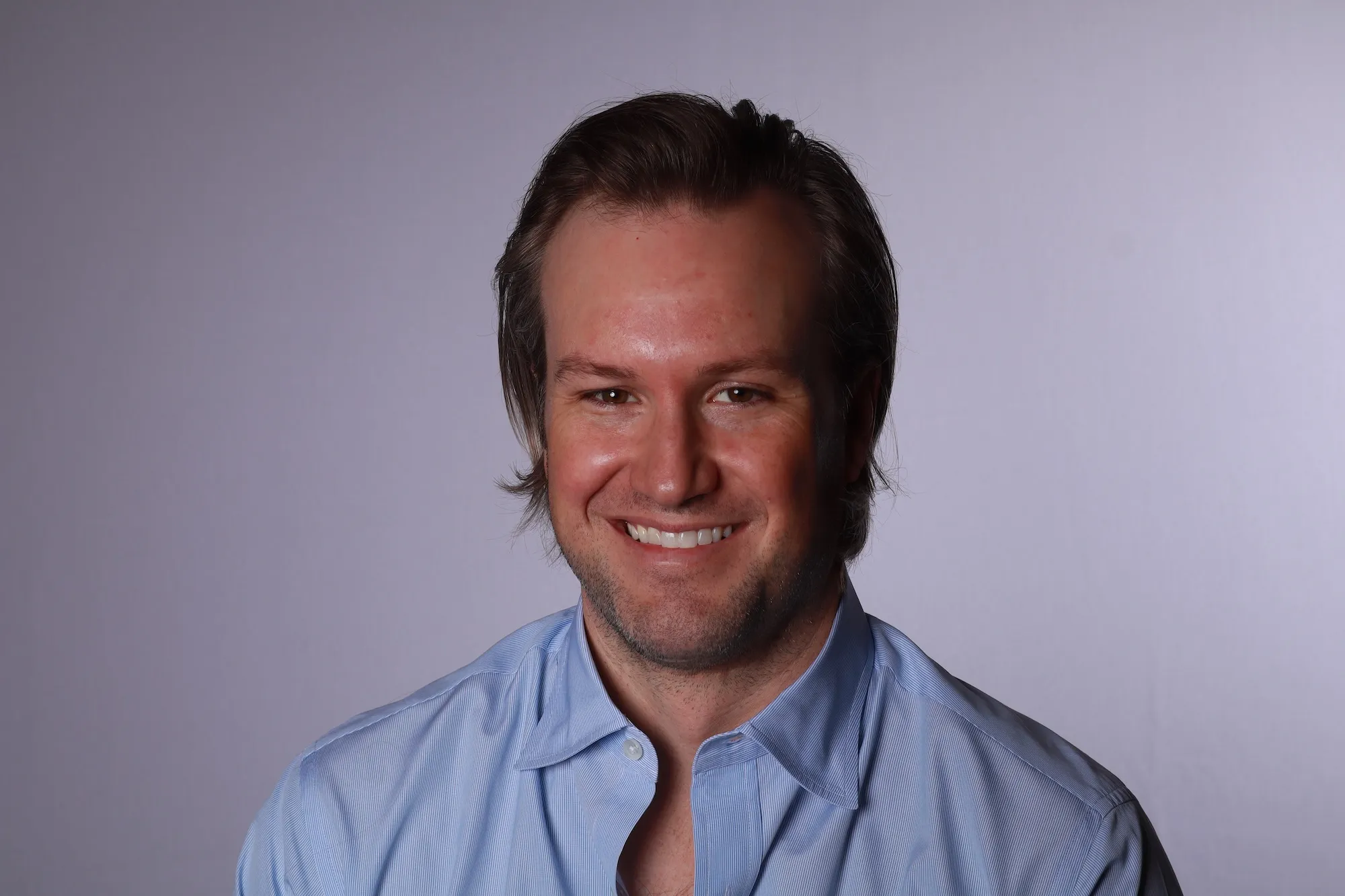 Dr. Reynolds Lawnin smiling in a light blue shirt