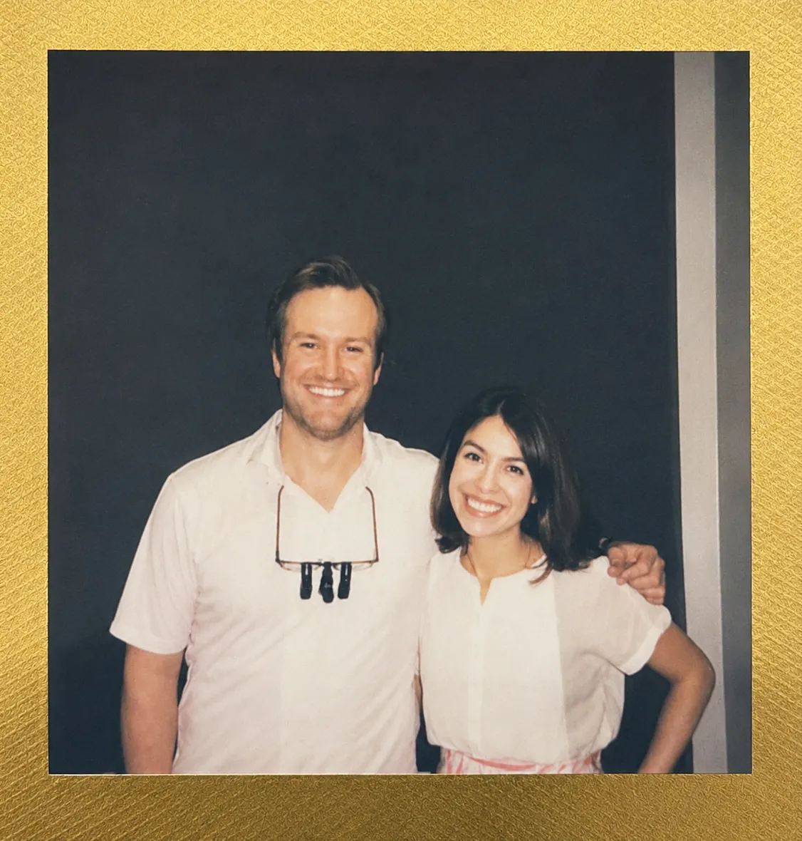 Dr. Reynolds Lawnin with a smiling woman in a white top, polaroid-style photo