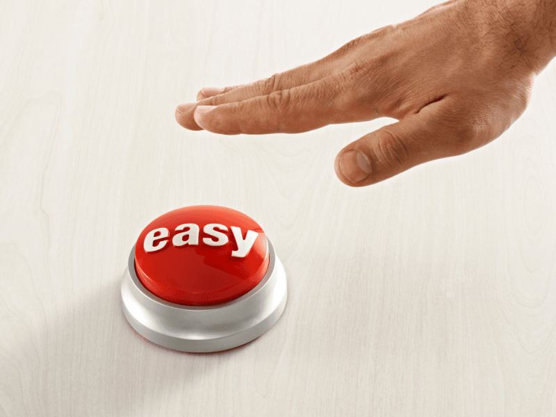 Hand pressing a red easy button symbolizing simple hotel phone system setup