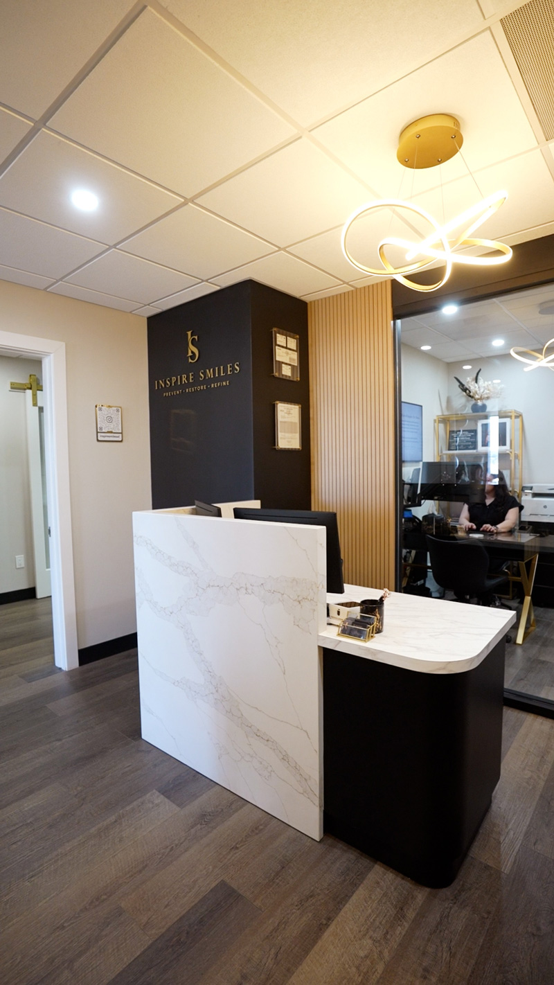Reception desk and Inspire Smiles brand wall at the Solana Beach dental office