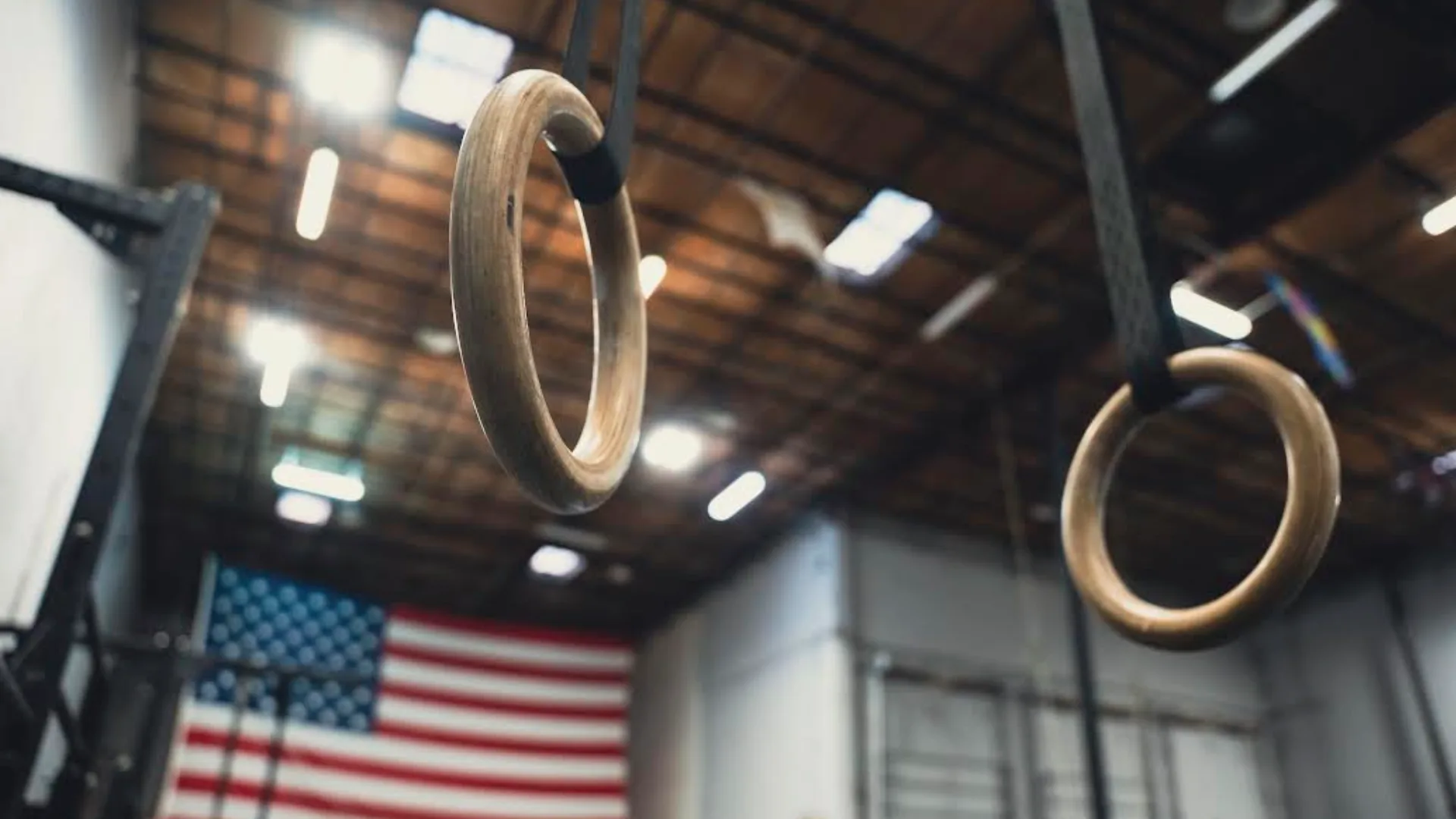 A woman lifts a barbell in a CrossFit gym at NOEQL Training Co. in Tampa, FL, showcasing strength and determination.