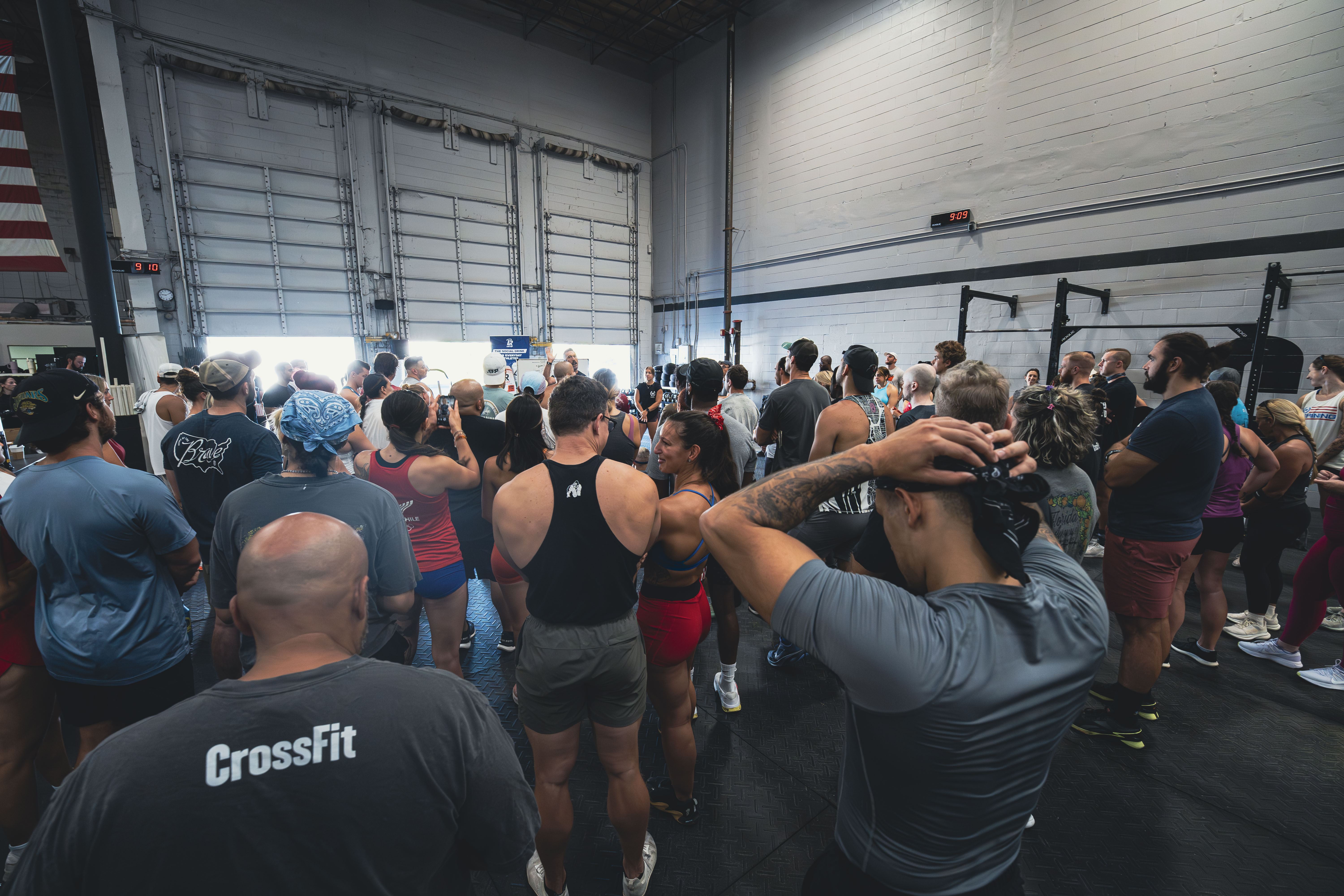 A woman lifts a barbell in a CrossFit gym at NOEQL Training Co. in Tampa, FL, showcasing strength and determination.