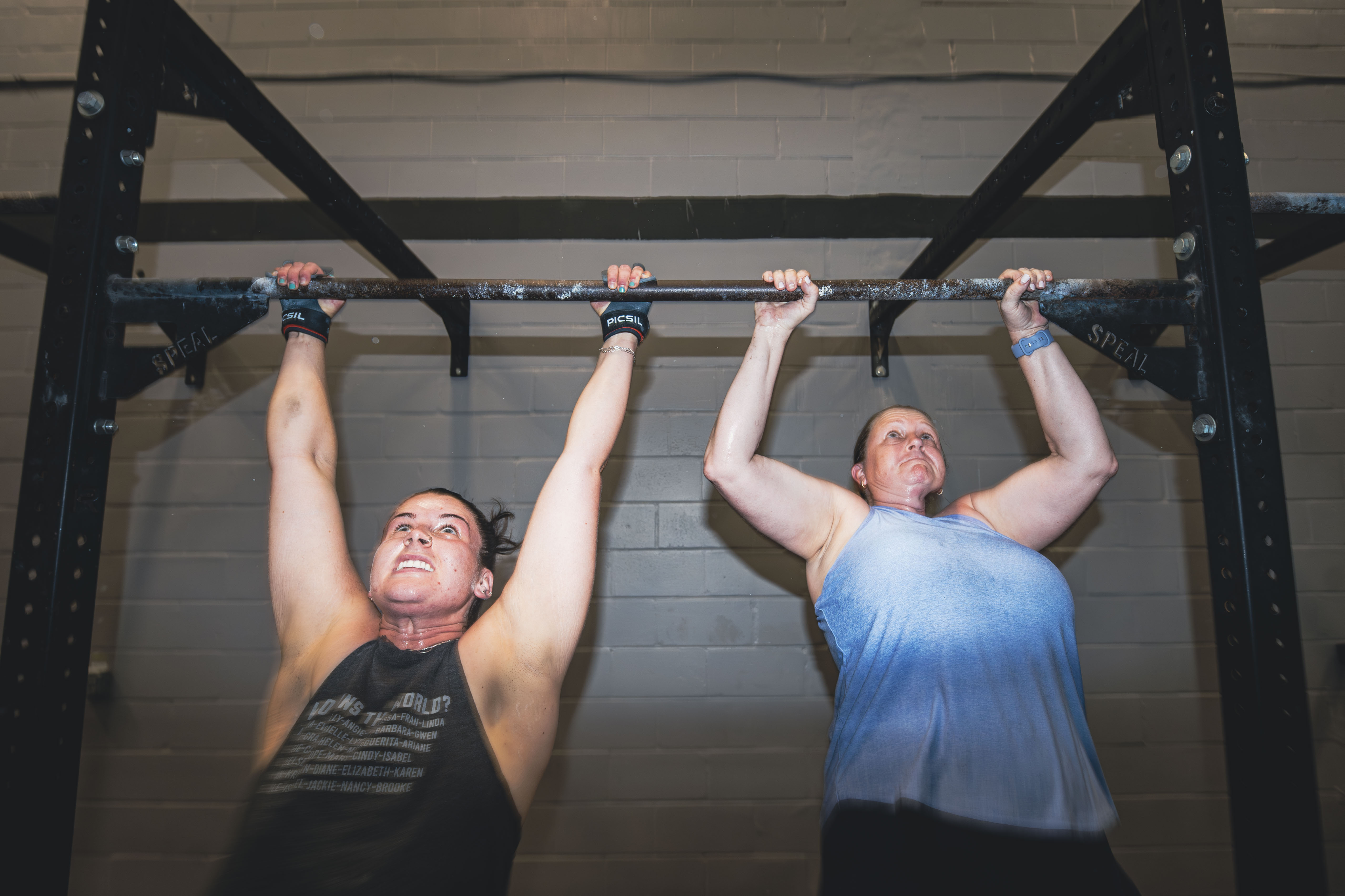A man performs a squat in a gym at NOEQL Training Co. in Tampa, FL, showcasing proper form and concentration.