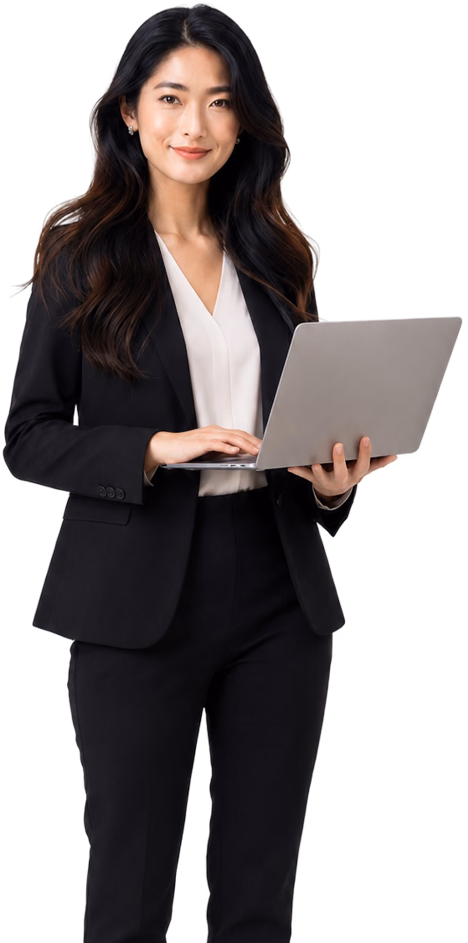Smiling woman in black suit holding and typing on a silver laptop.