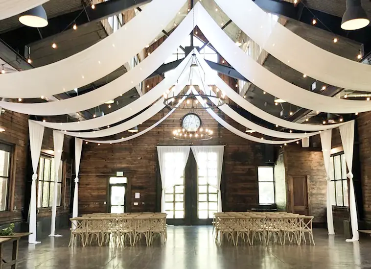 Venue hall with white draping and warm string lights