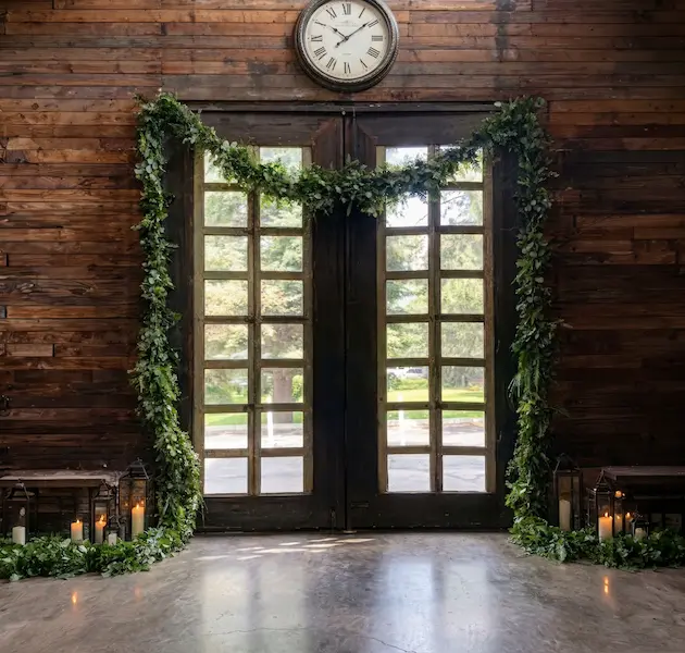 Barn doors framed with fresh greenery garland