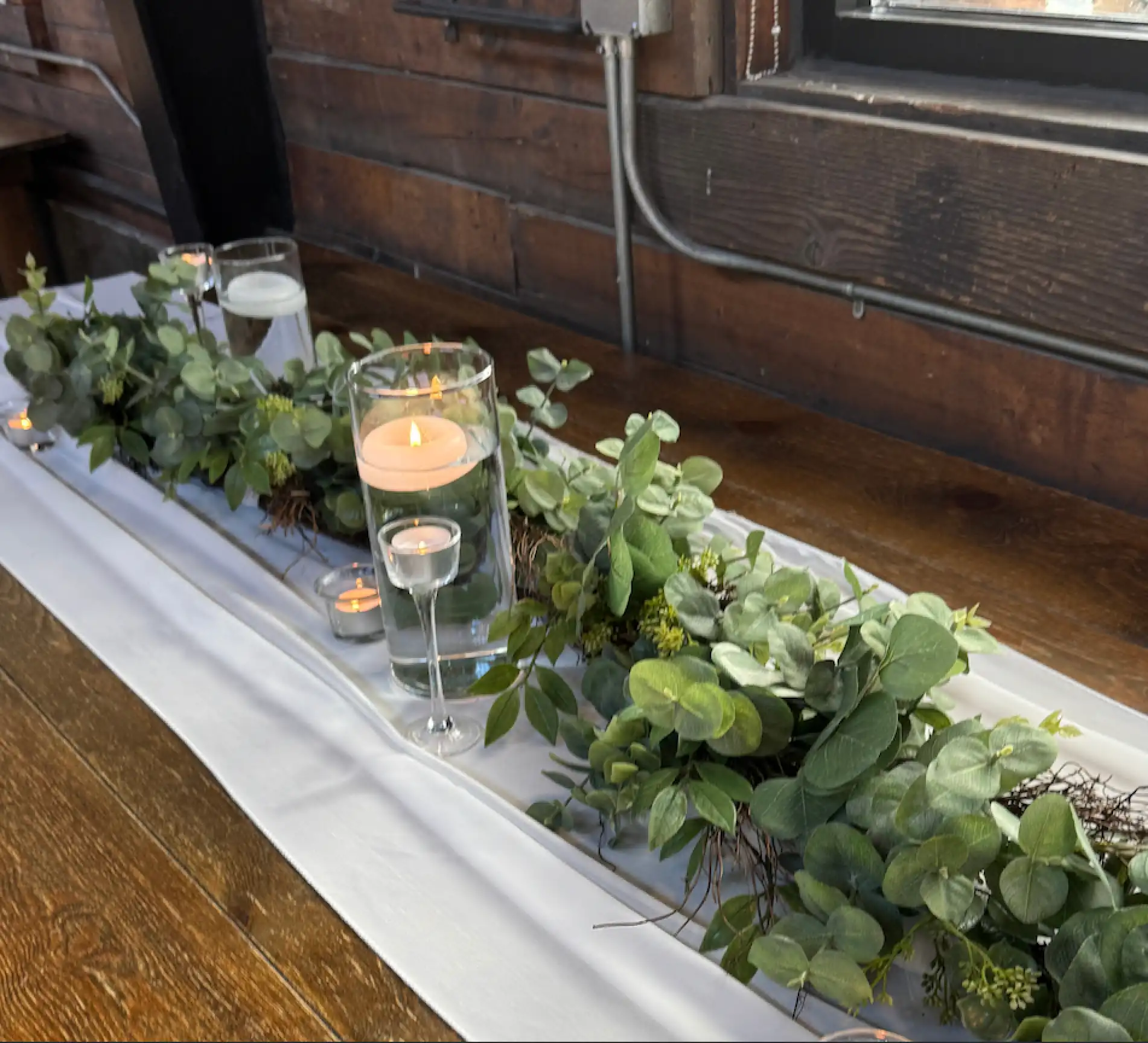 Table with runner, candles, and greenery