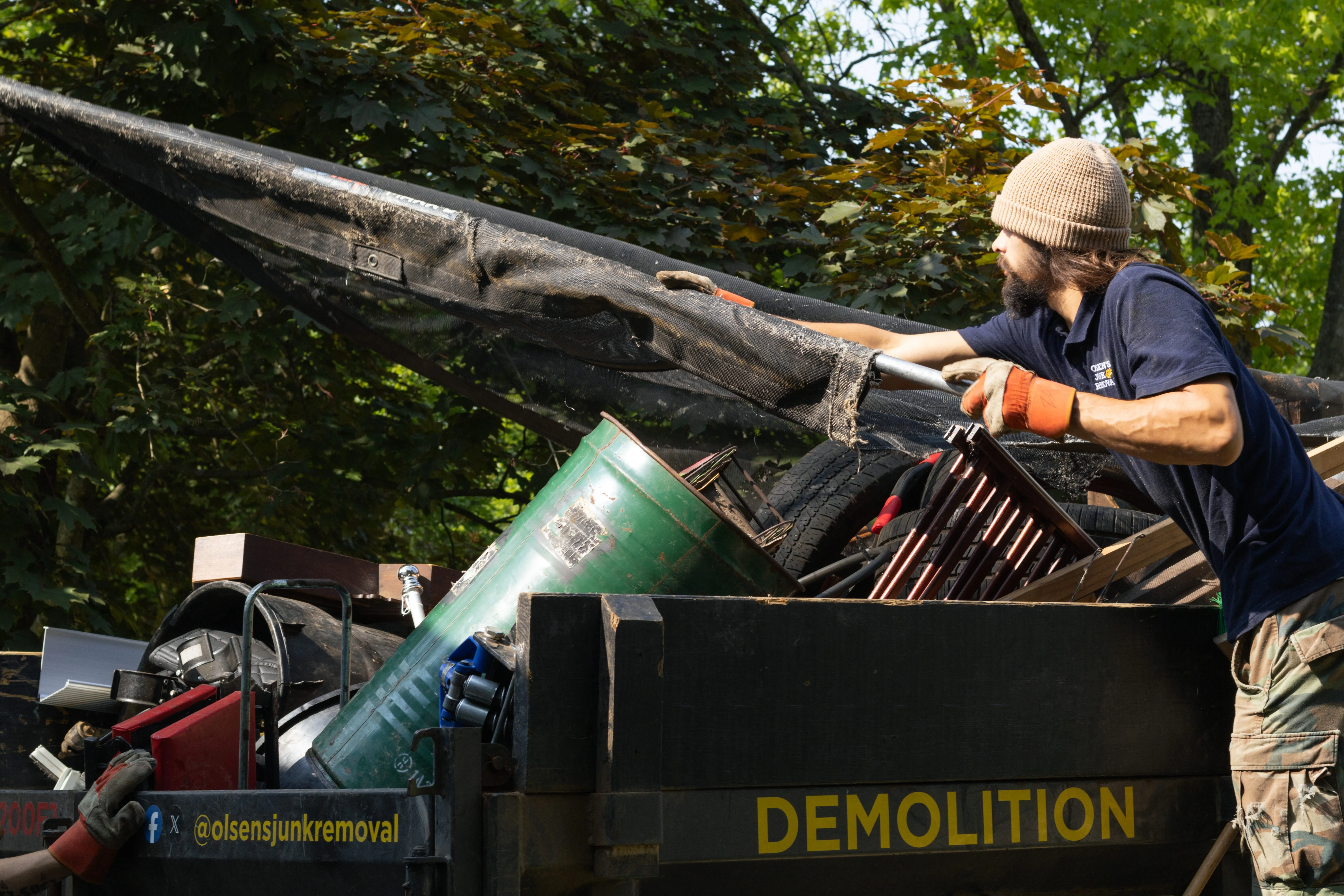 Crew member from Olsen's Junk Removal tapping a trailer after a garage cleanout in Wooster ohio