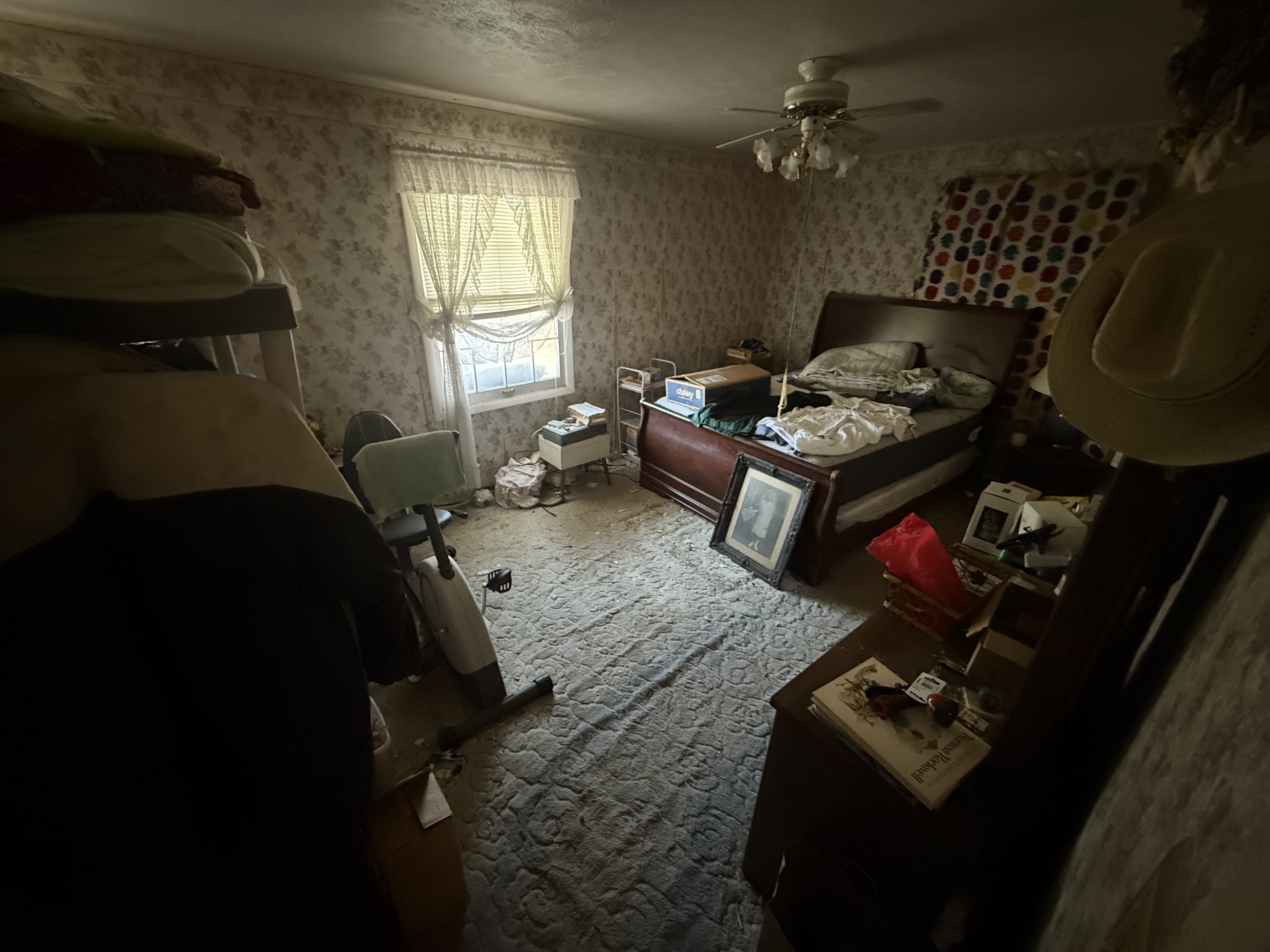 Home in Fairlawn/Bath full of clutter like a bed and dresser set with clothes all around it and on the floor