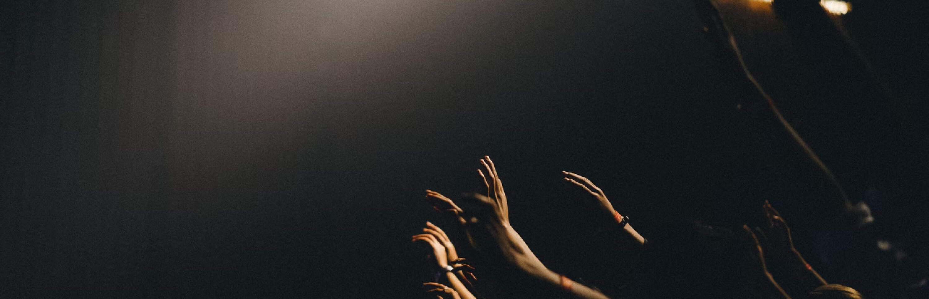 hands raised in spotlight