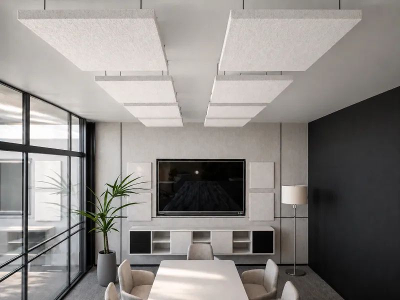 Modern meeting room with white table, gray chairs, black-and-white decor, and large TV on wall.