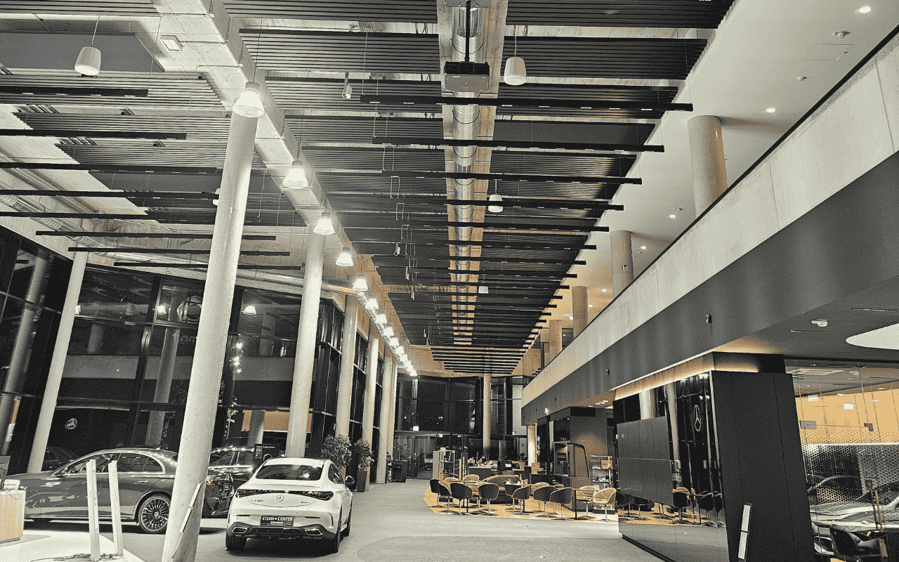 Schwarze Schallabsorber zwischen den Deckenheizungen im Autohaus-Showroom