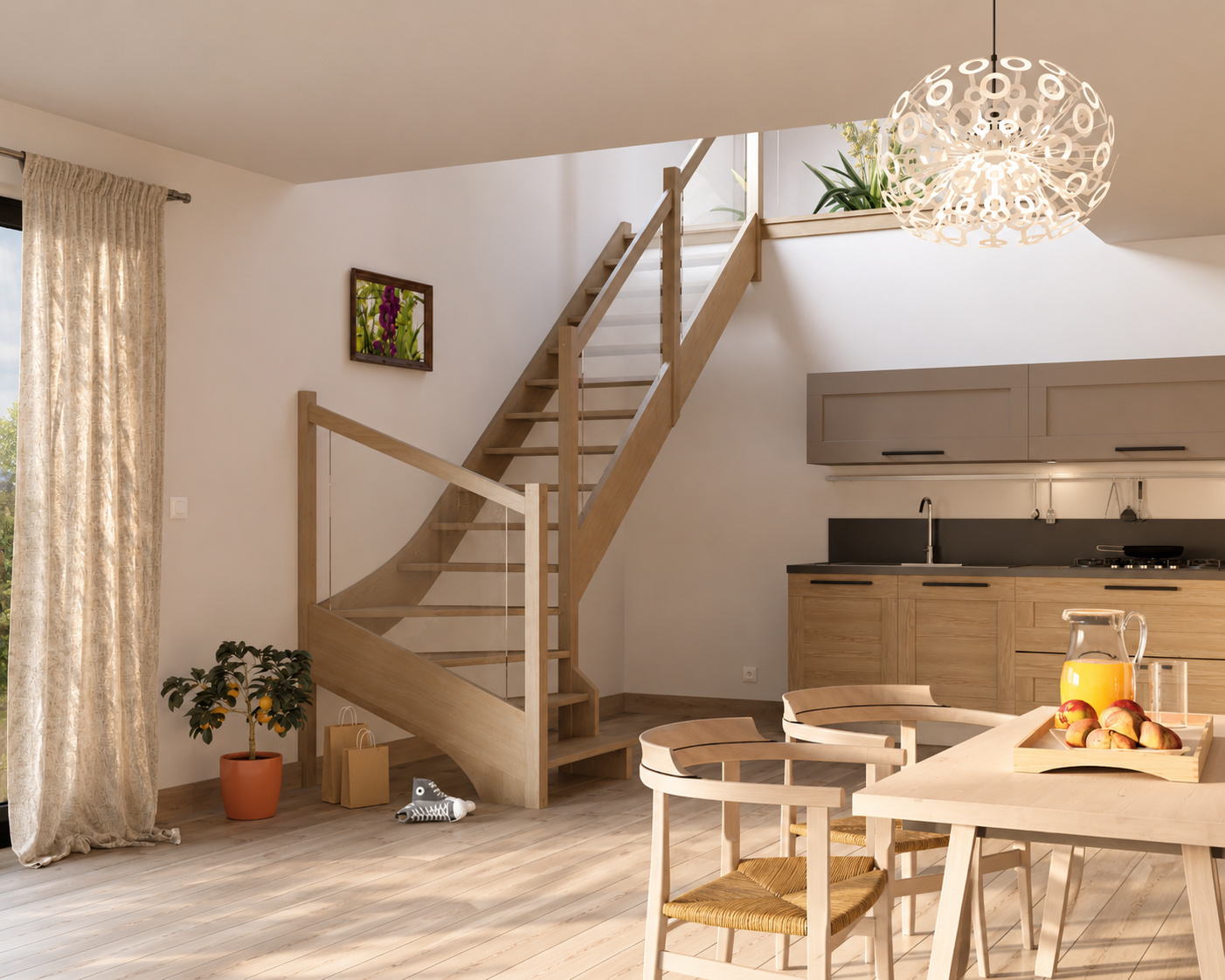 Cuisine et salle à manger lumineuses avec des meubles en bois clair, escalier en bois avec rambarde en verre, plante en pot avec fruit, tableau floral et table avec carafe de jus d'orange et fruits.