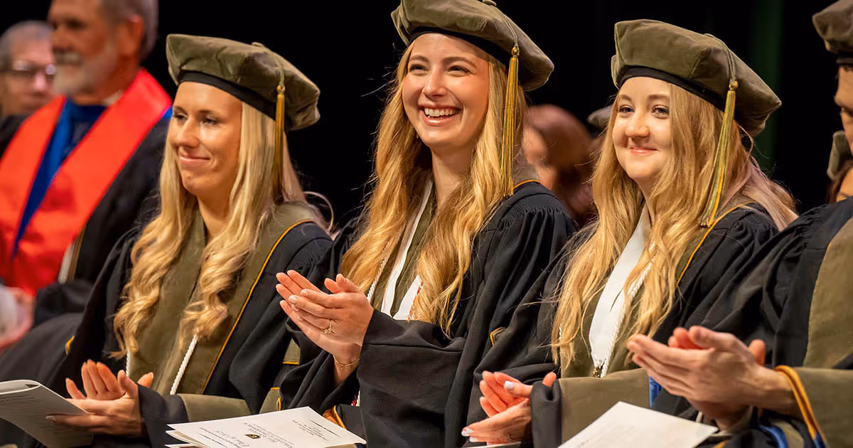 ETSU Bill Gatton College of Pharmacy 2025 graduates smiling and clapping during the commencement ceremony