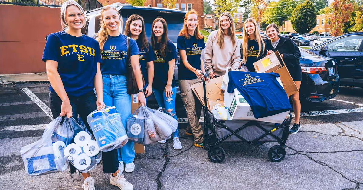 ETSU dental hygiene students posed together with the supplies gathered for hurricane relief efforts before they pack them in cars for distribution in the region