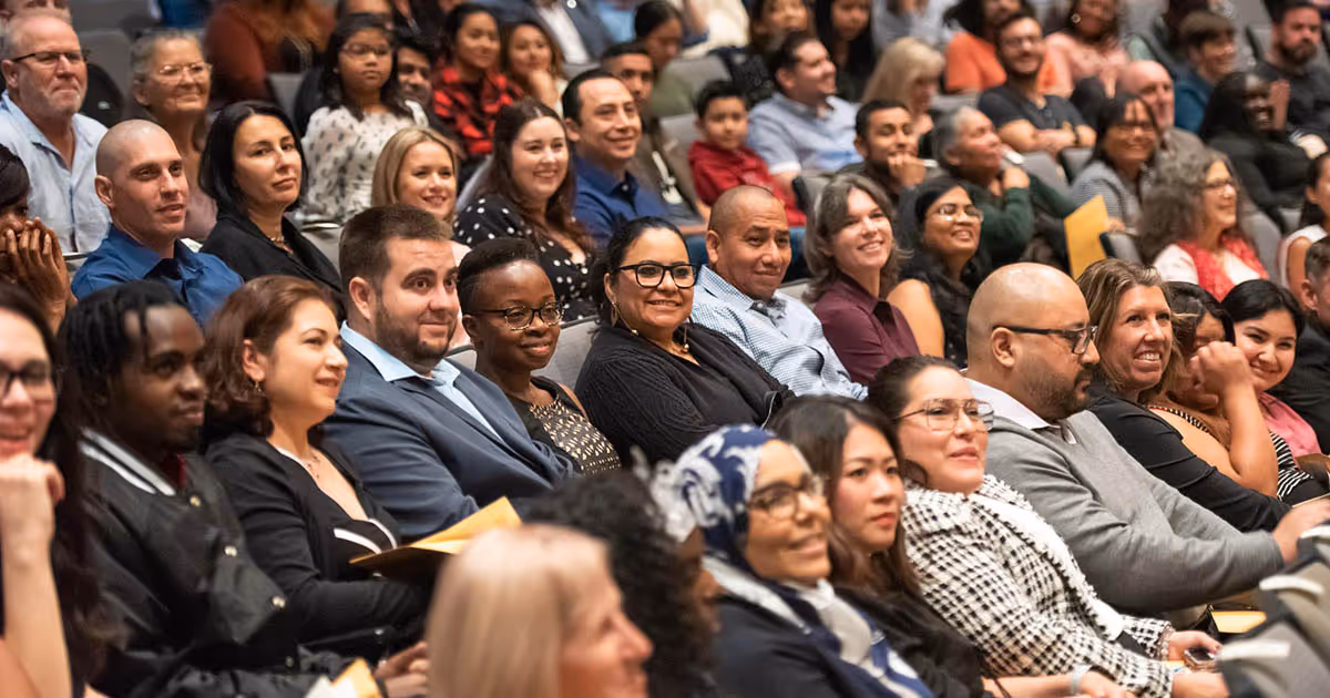 An audience shot in the Culp auditorium. Most people can be seen smiling.