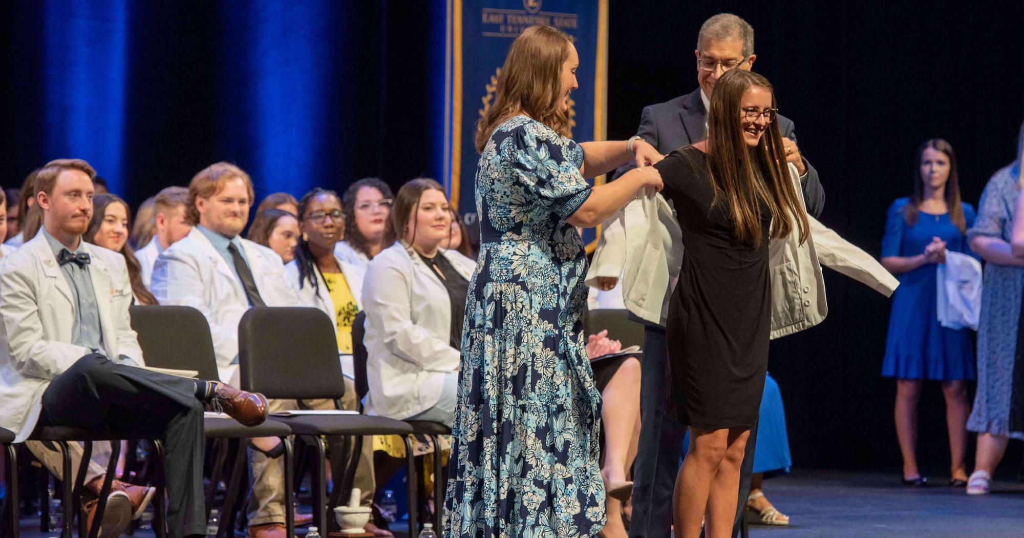 A Gatton College of Pharmacy student receives their white coat. 