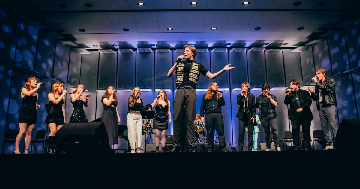 ETSU vocal ensemble delivers a lively group performance under dramatic stage lighting.