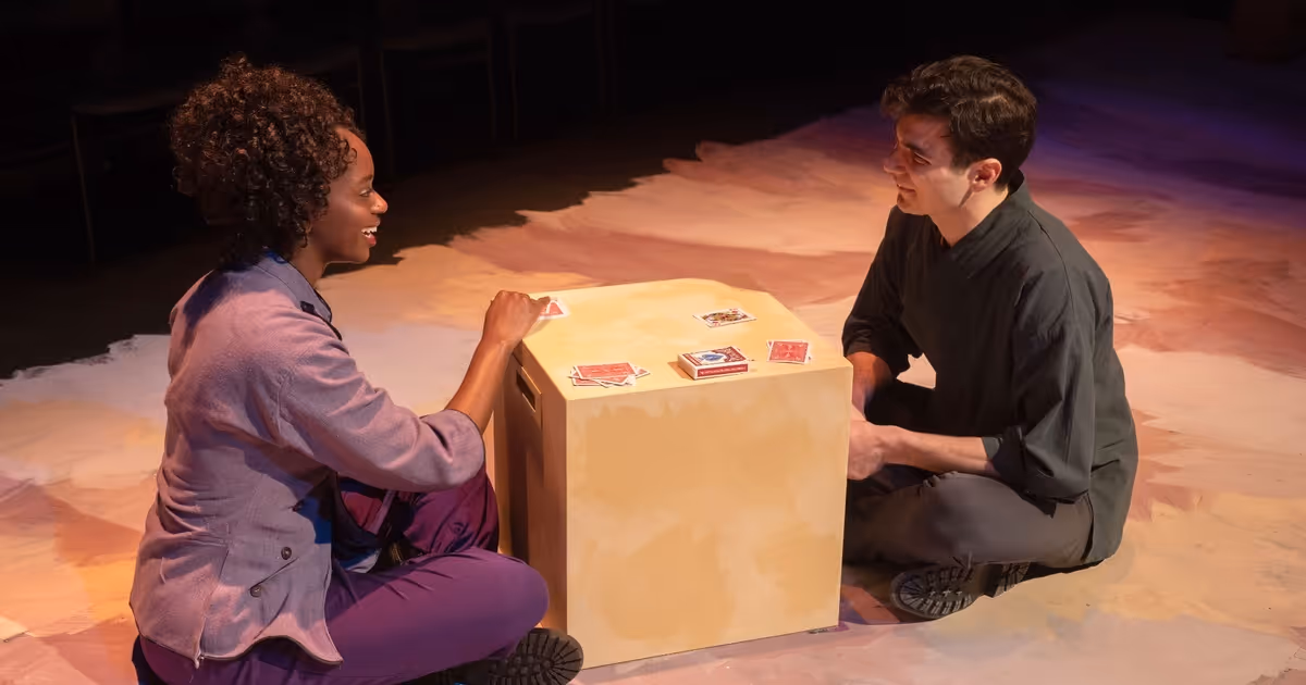 Two students play cards in "Passage."