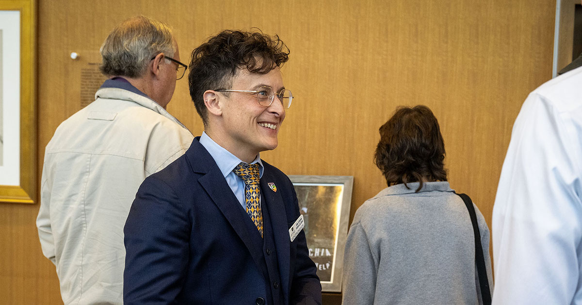 An attendee speaks with guests while viewing artwork displayed in the Martin Center during the arts showcase.