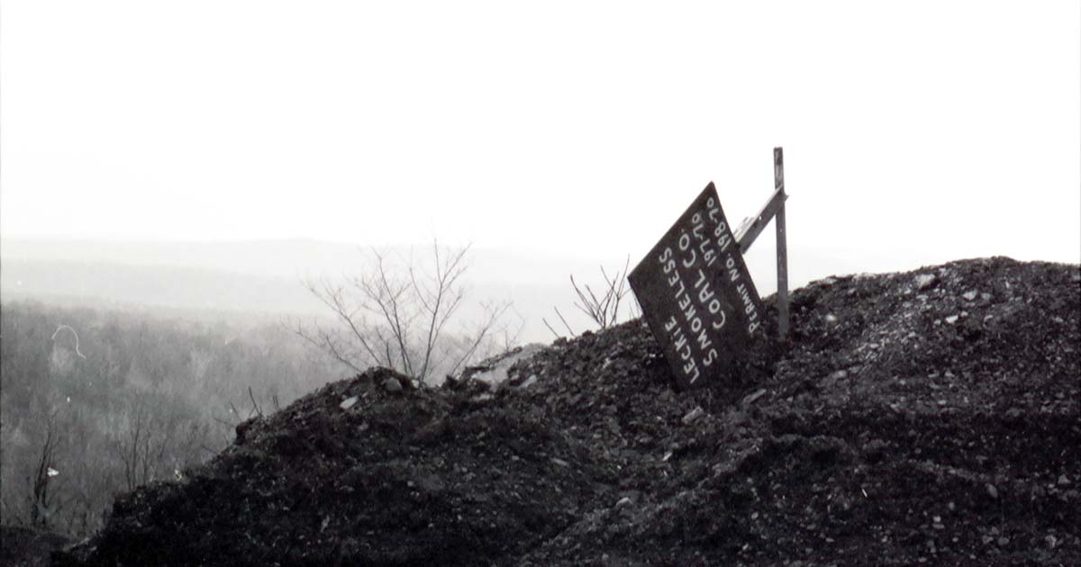 An overturned sign rests on top of a hill in Appalachia. 