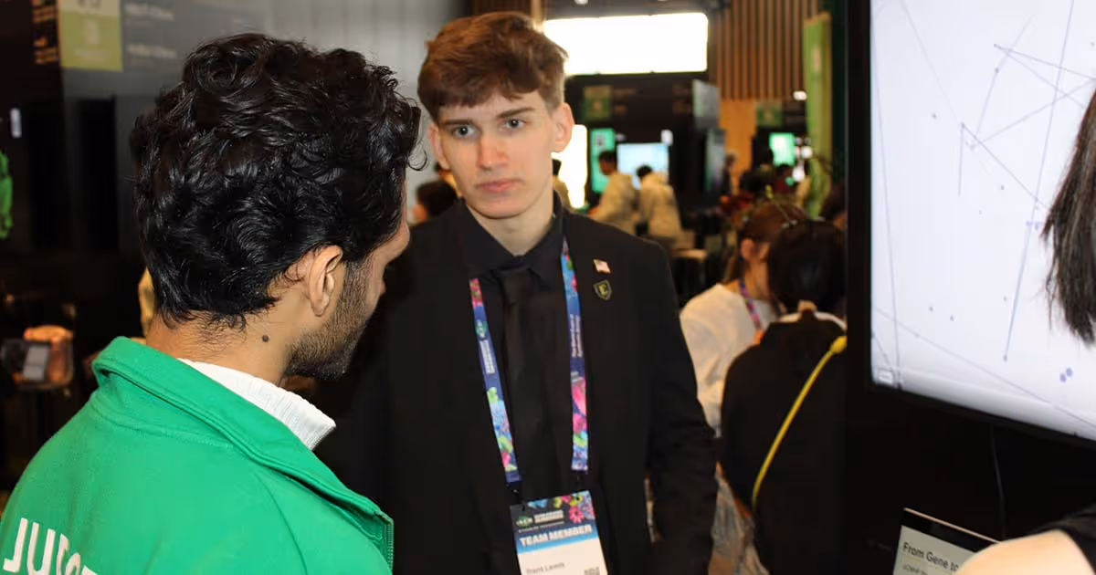 Trent Lewis speaks to another iGEM conference participant