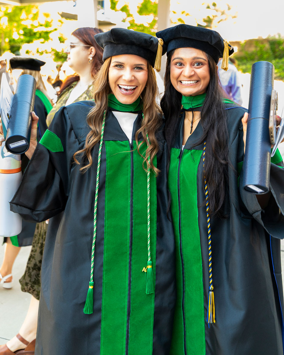 Two graduates from ETSU Quillen College of Medicine pose with their diplomas