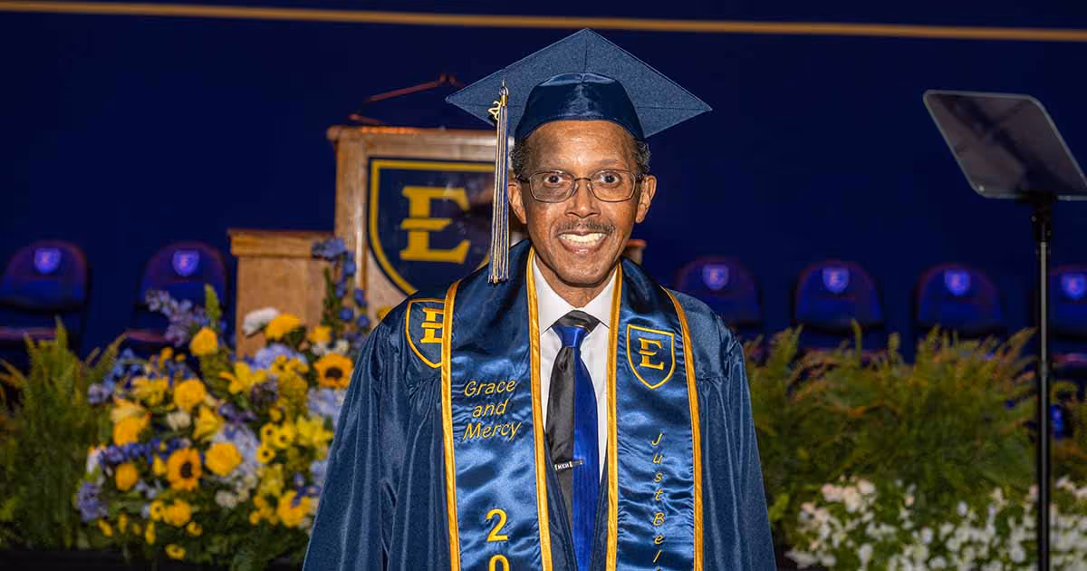 ETSU graduate Homer Eugene Henley Jr. poses in cap and gown during commencement.