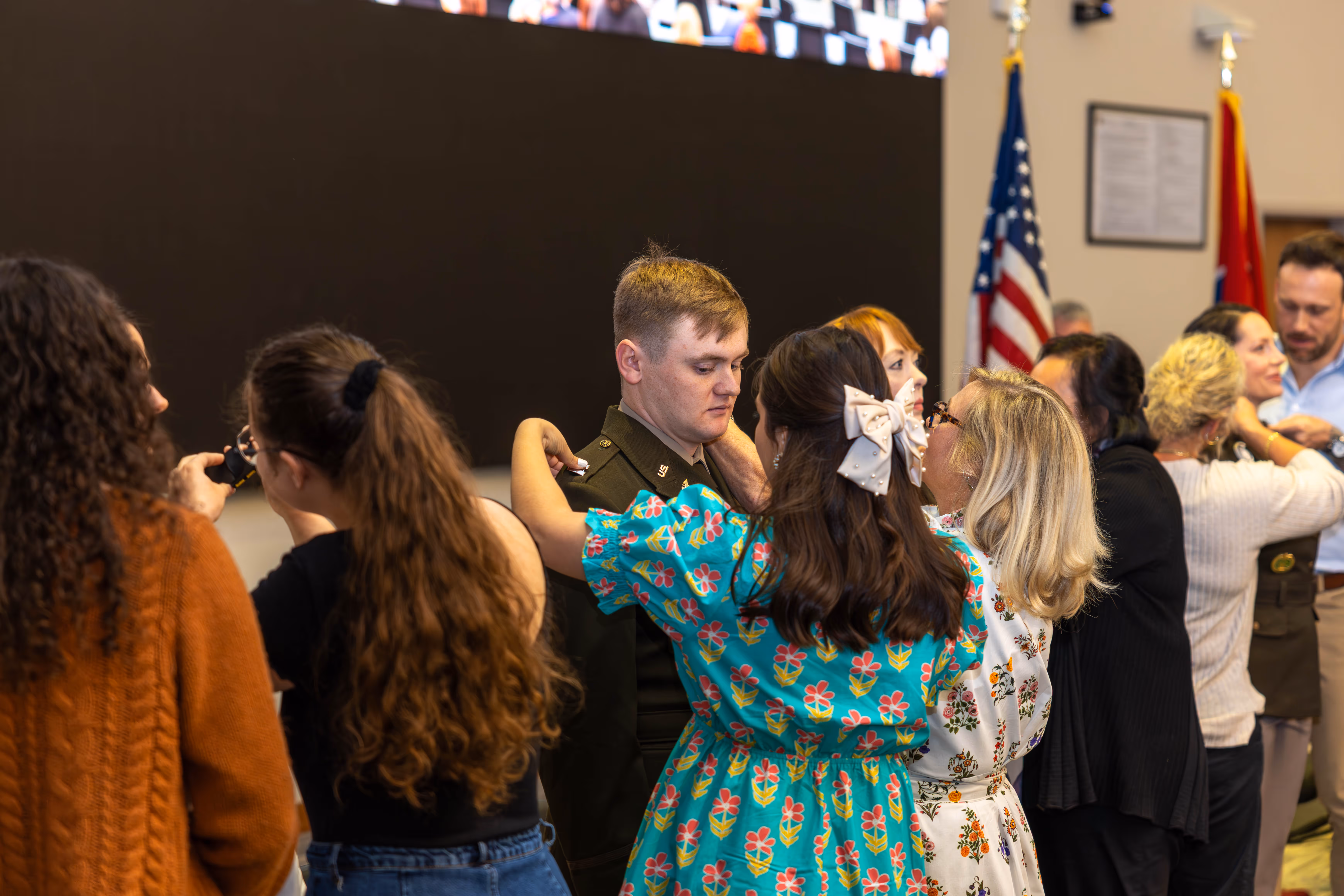 A Quillen graduate has his military rank pinned on his collar while looking down at his collar. 