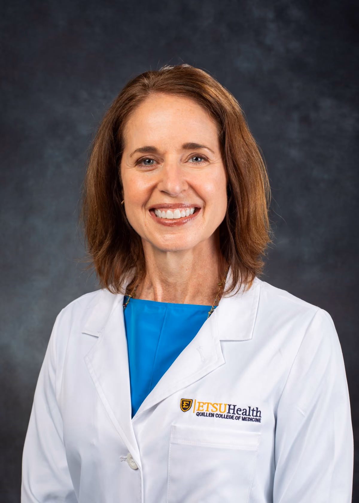 A headshot photograph of Dr. Dawn Tuell wearing her white coat.