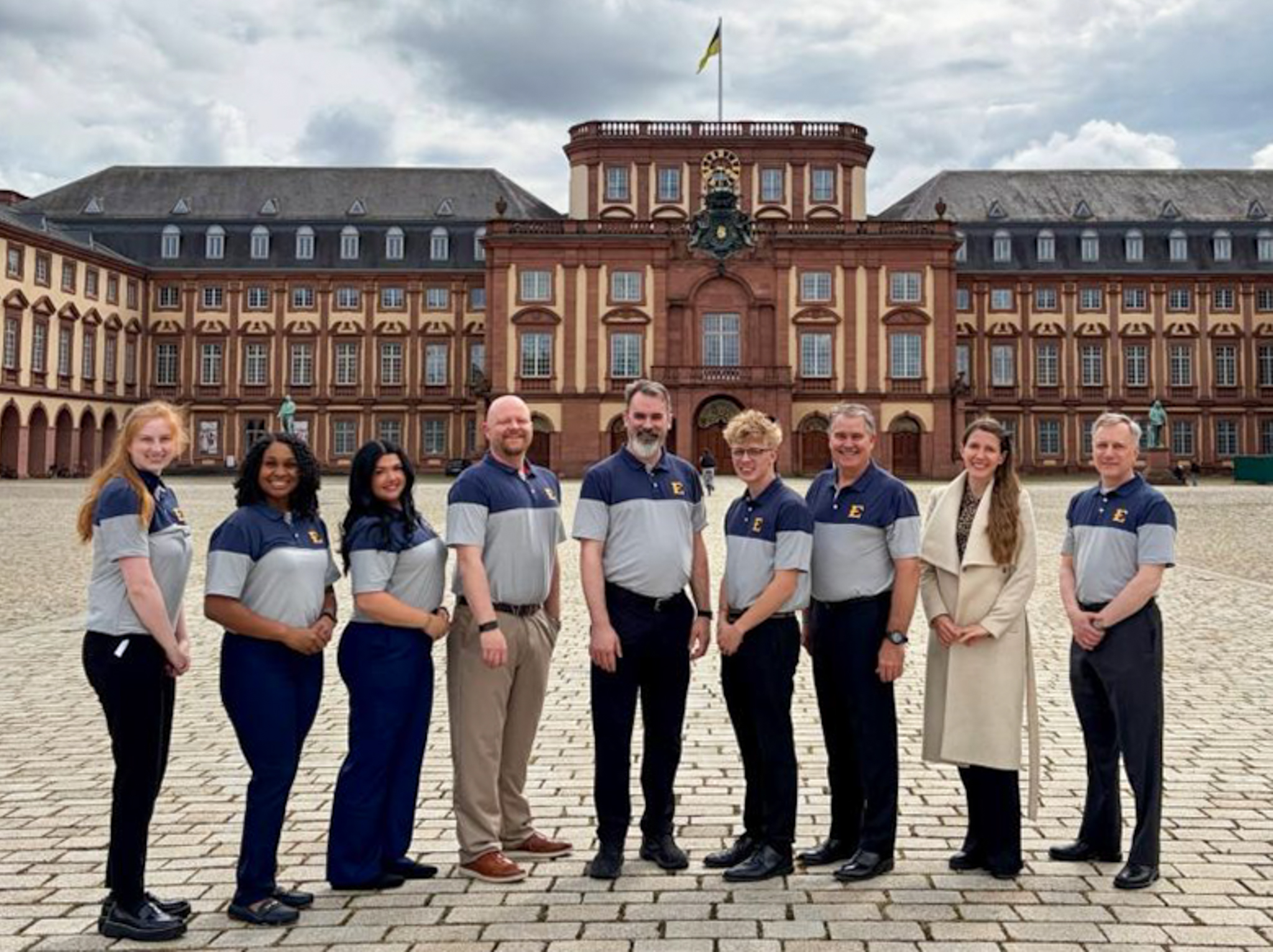 Nine total people including ETSU faculty and students smile outside of a facility during their Germany trip.