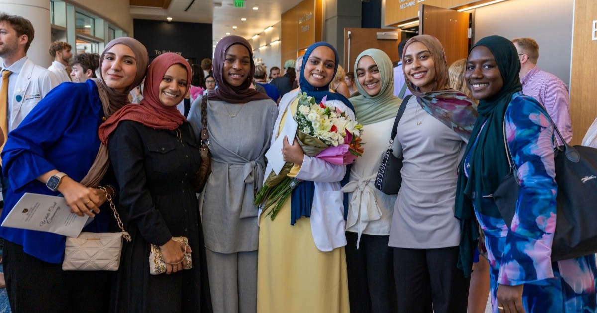 A Quillen College of Medicine student poses for a photo with her family after receiving her white coat.