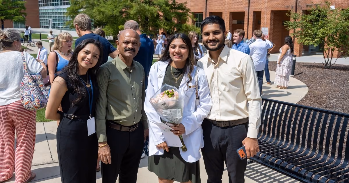 A member of Gatton's Class of 2030 poses for a photo with her family outside following the event.