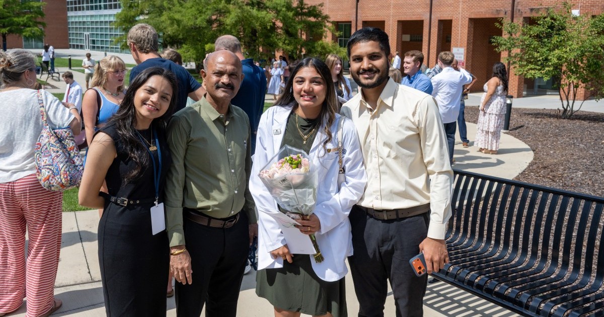 A member of Gatton's Class of 2030 poses for a photo with her family outside following the event.