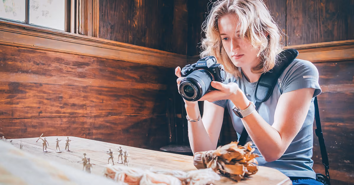 An ETSU student photographing historical figurines at Sycamore Shoals State Historic Site
