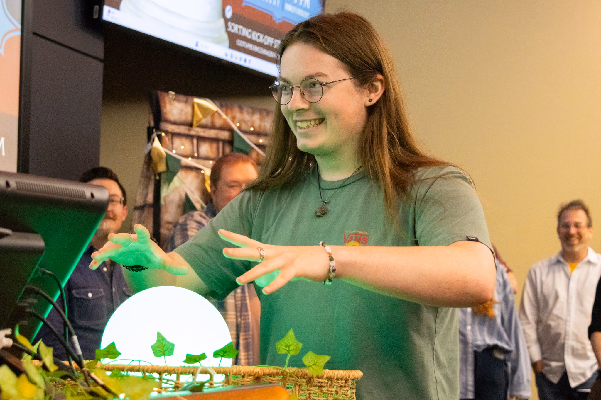 An ETSU CBAT digital media student smiles as they circle the orb with their hands at the midpoint sorting event.