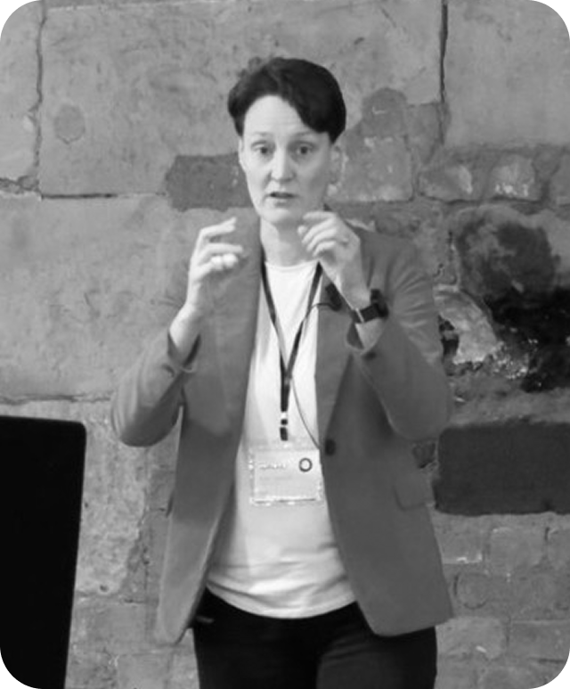 Black and white photo of Kate Gawron talking on stage