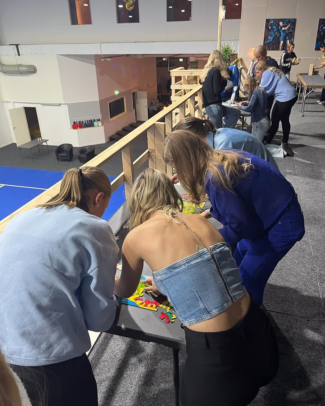 Personer står i en ring och fokuserar på en klurig utmaning hos Nyköpings Eventcentra.