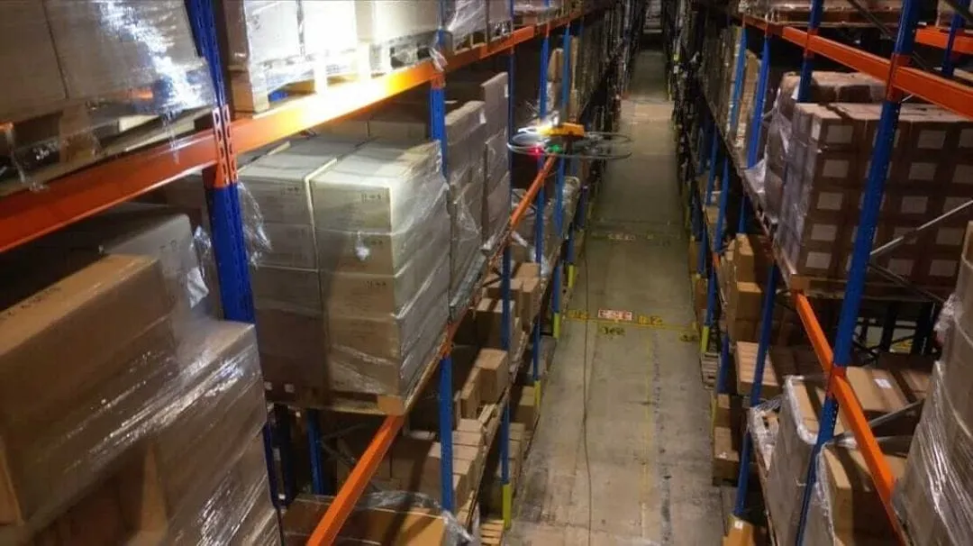 Inventory drone flying in a racked warehouse