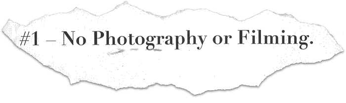 Torn paper with the text 'Rule #1 – No Photography or Filming.